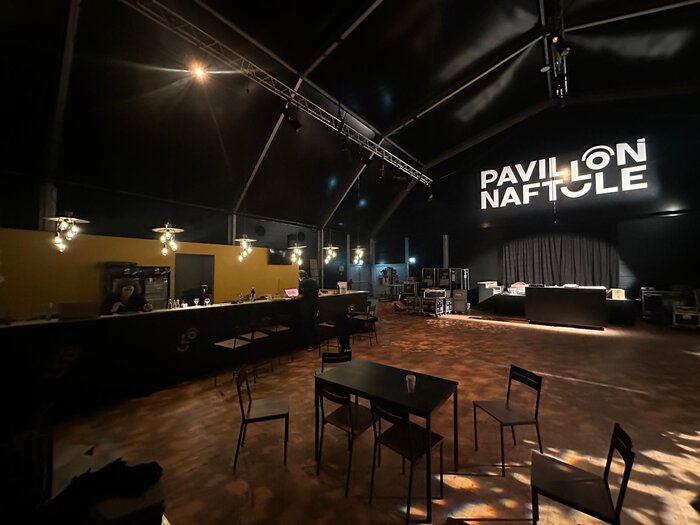 Innenansicht eines temporären Pavillons von Naftule mit stimmungsvoller Beleuchtung