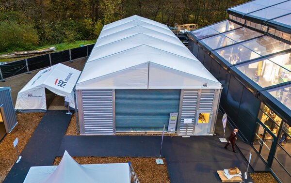 Lightweight industrial hall with aluminium frame and white tent roof, erected on company premises