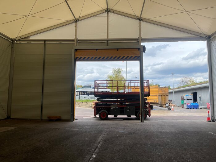 Innenansicht einer geöffneten Lagerhallentür mit Hebebühne