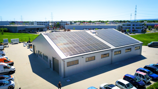 Modern temporary industrial building with aluminium cladding and large solar panels on the roof