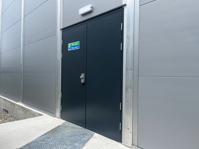 Notausgangstür einer Industriehalle mit Hinweisschild