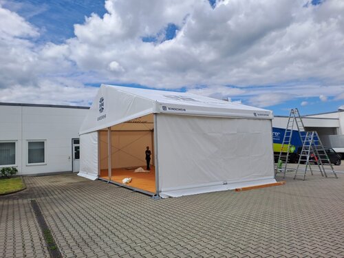 Marquee on a paved surface under a slightly cloudy sky