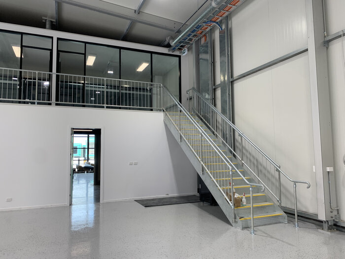 Upstairs office unit with a glass front in a modern warehouse