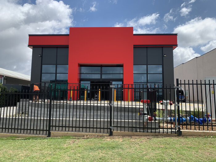 [Translate to English:] Moderne Lagerhalle mit roter Fassade und Glasfront
