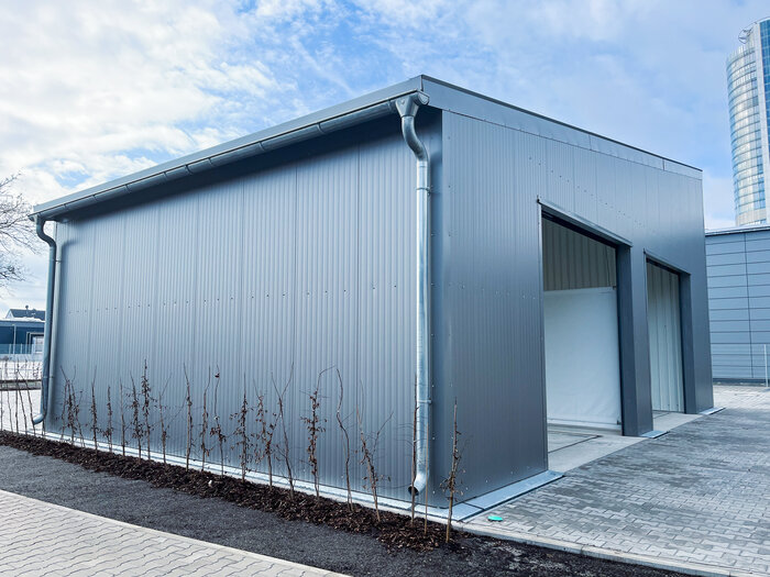 Corner view of industrial cargo hall with monopitch roof and gutter