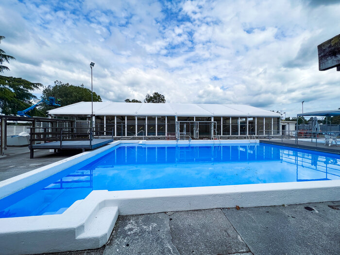 Swimming pool in front of a large tent under a cloudy sky
