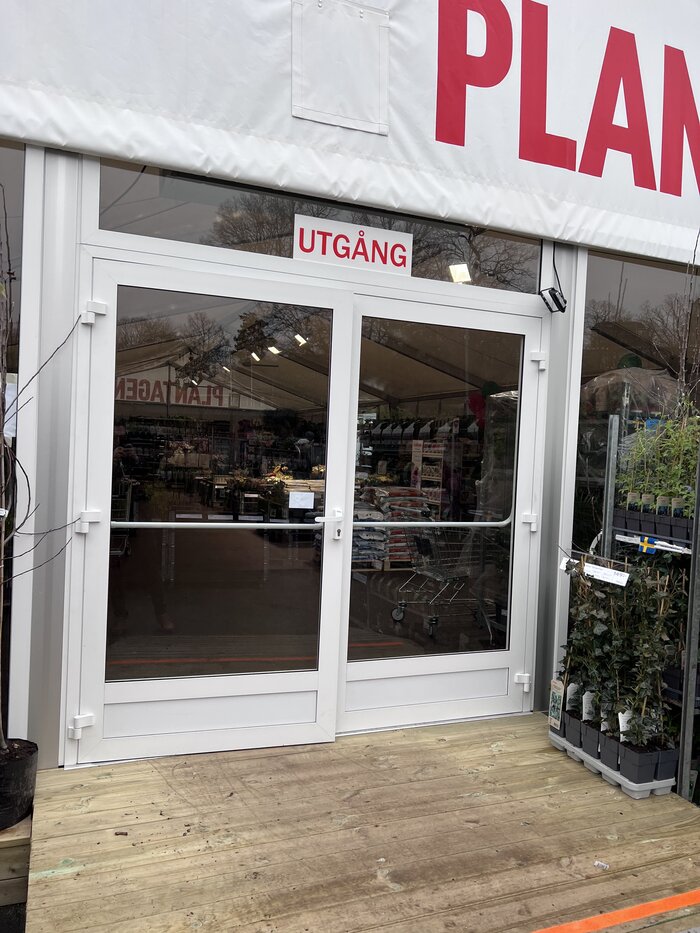 Nahaufnahme einer Glastür mit Ausgangsschild an einem Eventzelt