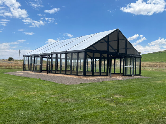 Schwarzes Event Festzelt mit Glasrahmen auf Wiese