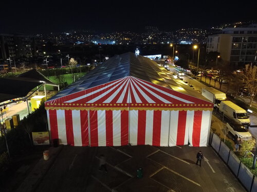Event-Festzelt bei Nacht mit rot-weißen Streifen