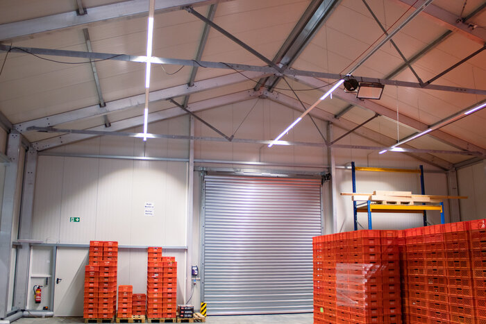 Insulated warehouse interior with roller door and plastic storage crates