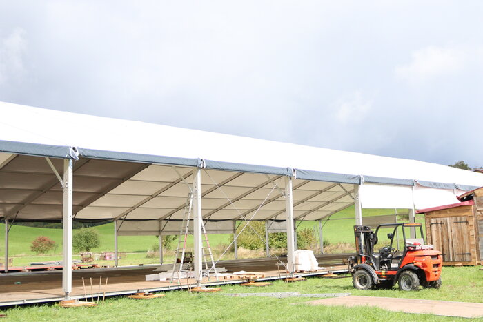 Teilweise aufgebautes Festzelt mit Gabelstapler
