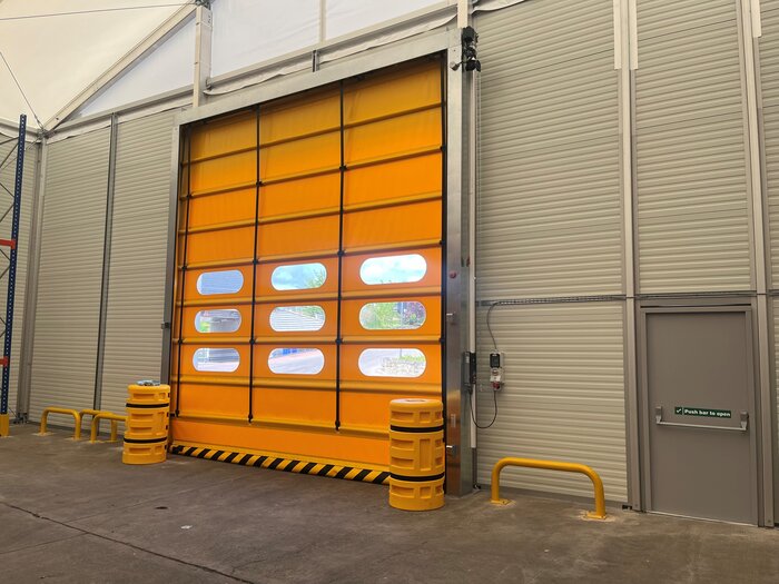 Detailaufnahme der Innenansicht eines gelben Schnelllauftors in einer Lagerhalle