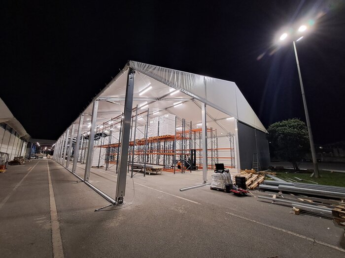 Beleuchtete Industriehalle mit Regalen bei Nacht