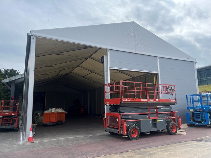 Außenansicht einer geöffneten isolierten Lagerhalle mit Hebebühnen