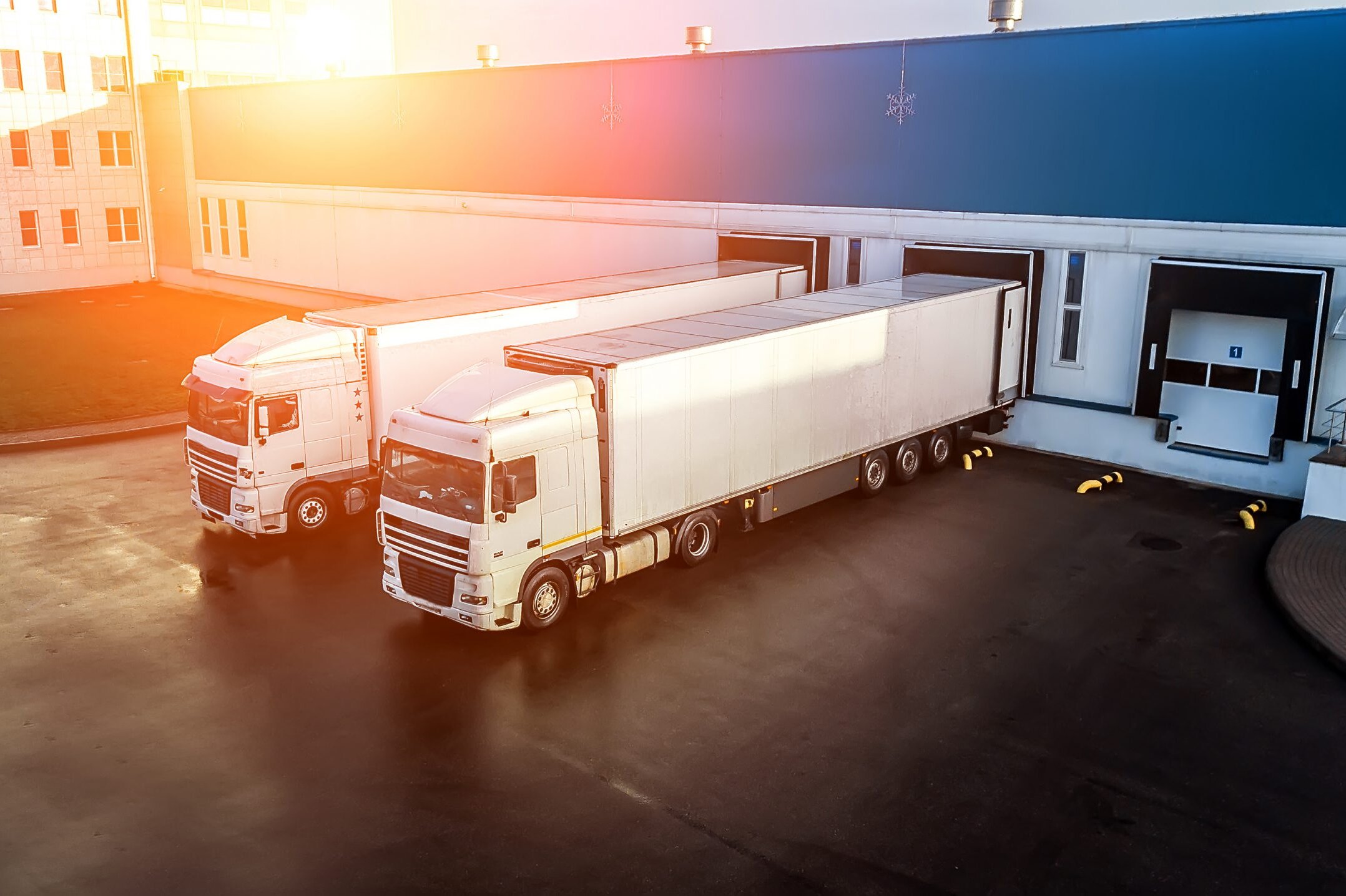 Zwei Lkw an einem Logistikzelt bei Sonnenaufgang
