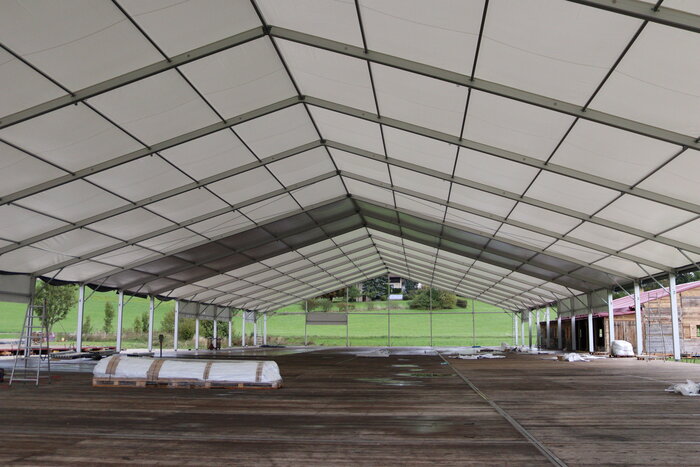 Innenansicht eines teilweise aufgebauten Festzelts mit Holzboden