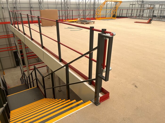 Innenansicht einer Industriehalle mit Stahlplattform und Treppe