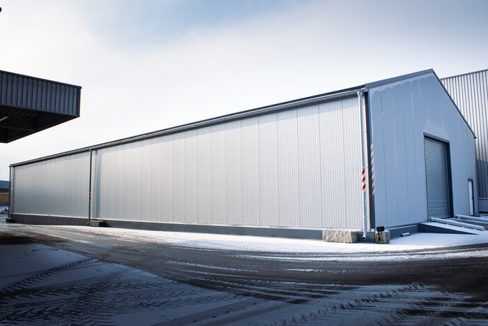 Exterior view of an insulated warehouse with roller door in winter