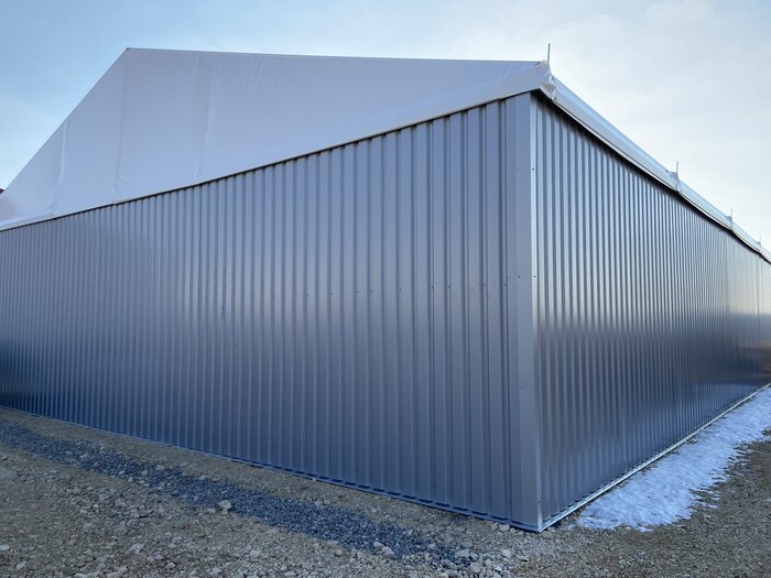 Corner of a mobile warehouse with trapezoidal sheet metal wall and PVC roof
