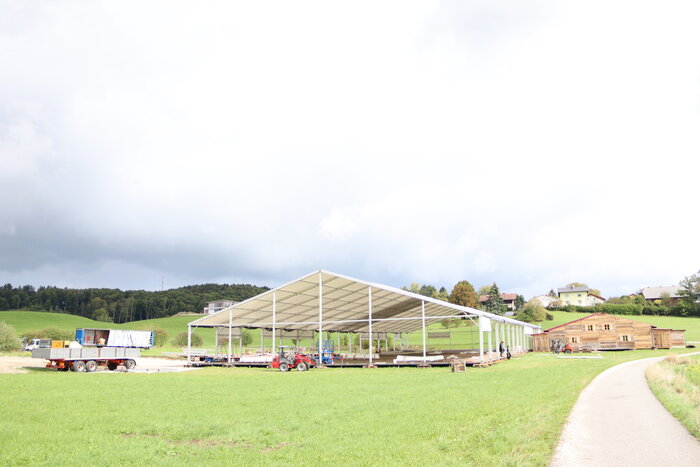 Aufbau eines großen Festzelts auf grüner Wiese 