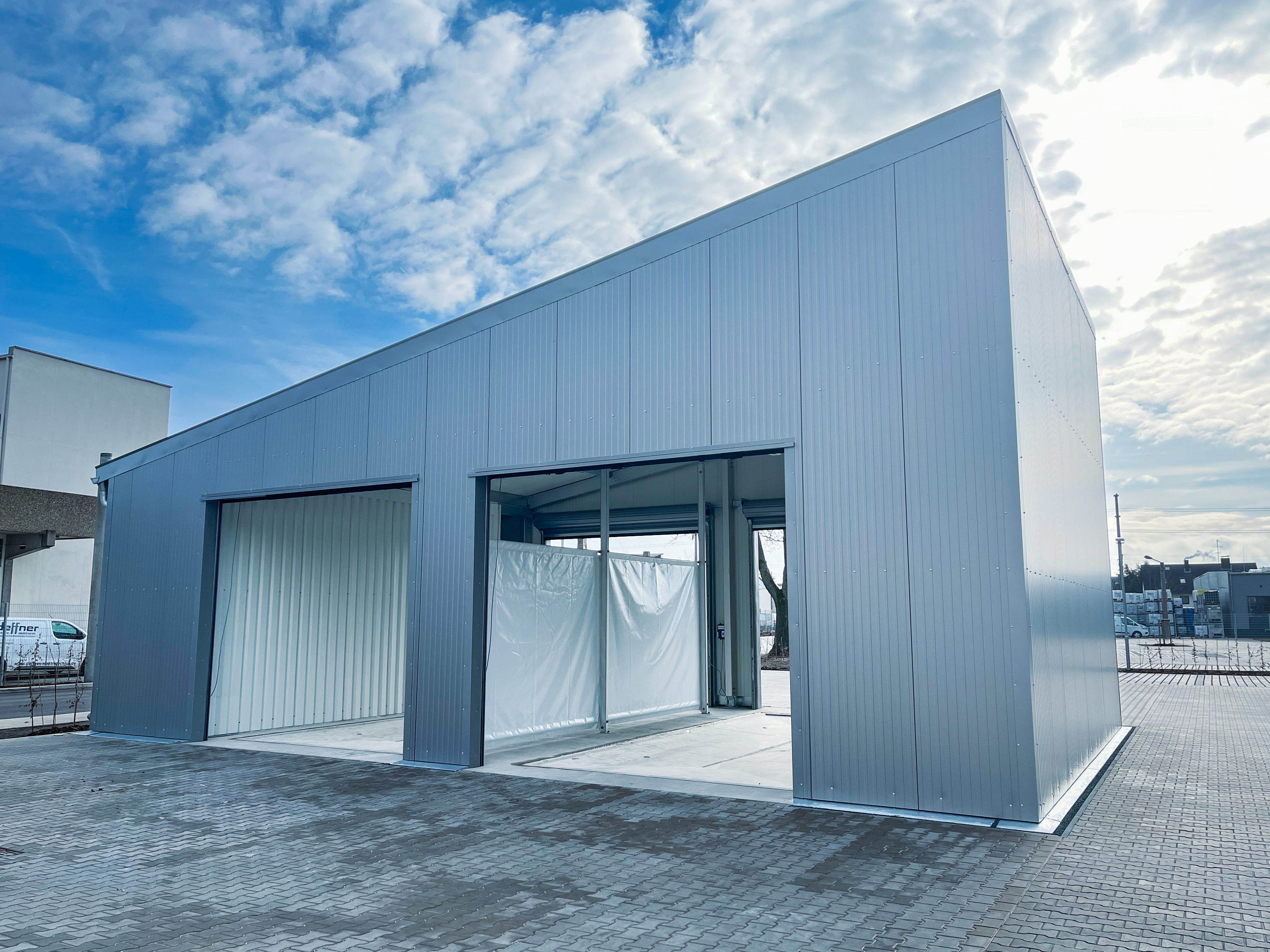 Exterior view of industrial cargo hall with monopitch roof and PVC partition