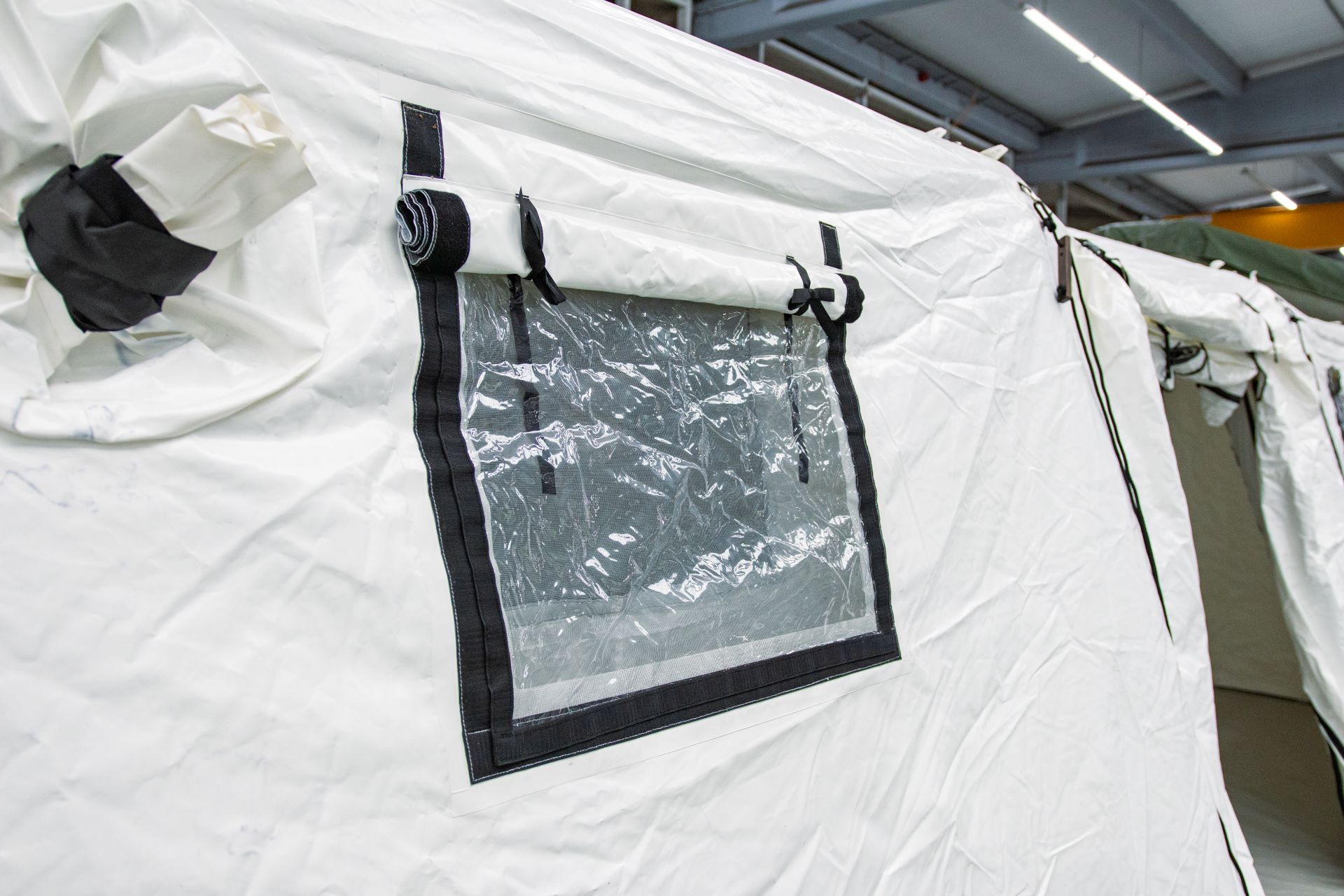 Nahaufnahme eines geöffneten Fensters mit transparenter Abdeckung am Rettungszelt MZI 42.